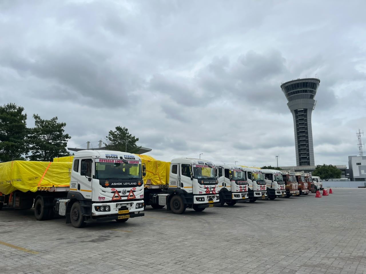 Fleet lineup on the tarmac beside the airport control tower