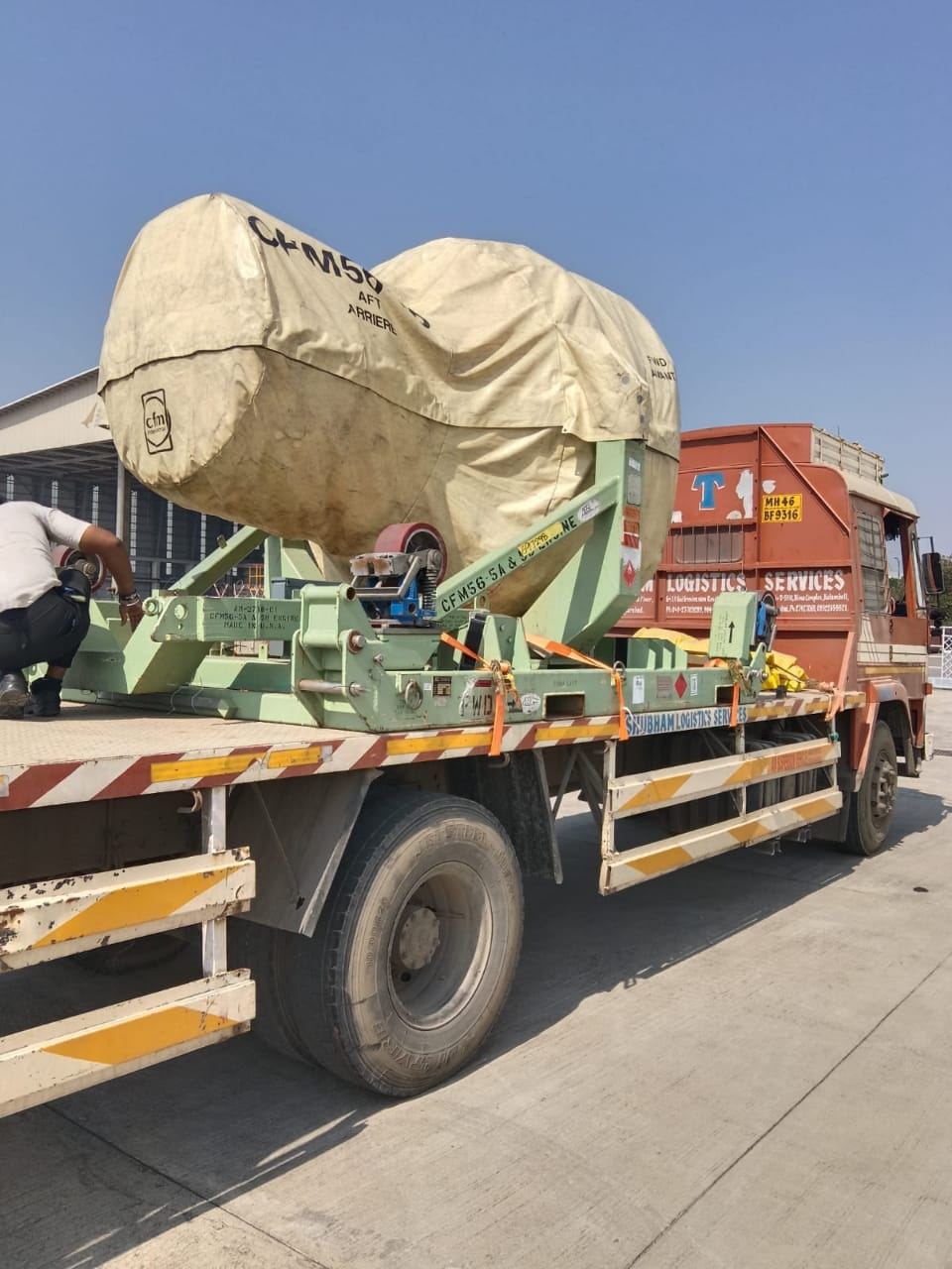 Flatbed carrying a shrouded jet engine assembly