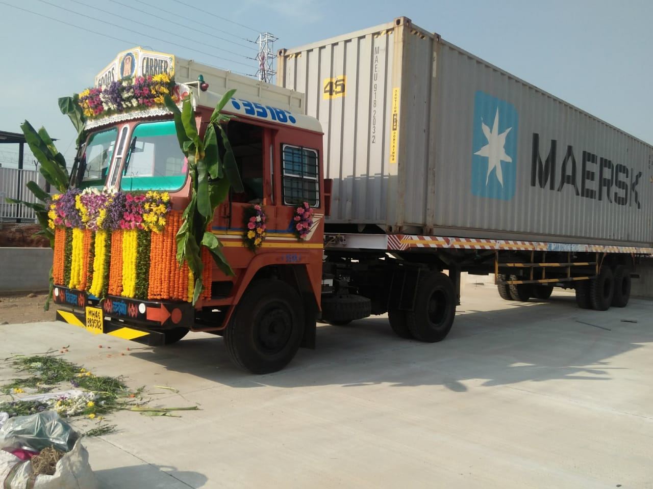 Decorated vehicle alongside a Maersk shipping container